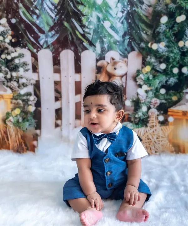A winter wonderland in our Bengaluru studio. This little boy looks so handsome in his suit against our festive Christmas-themed backdrop.