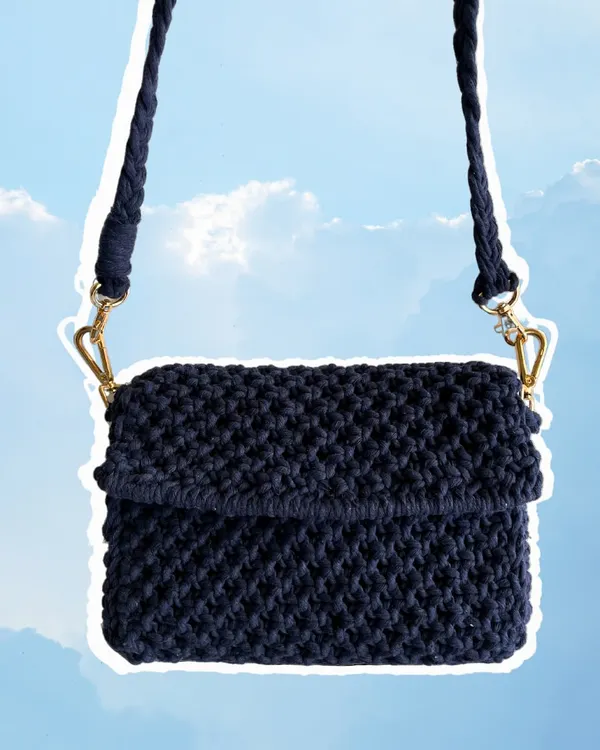 This is a classic macrame sling bag in a deep navy blue. It's a great everyday bag with a sturdy, knotted texture and a braided strap. We can customize the color and size to create the perfect bag for your aesthetic.