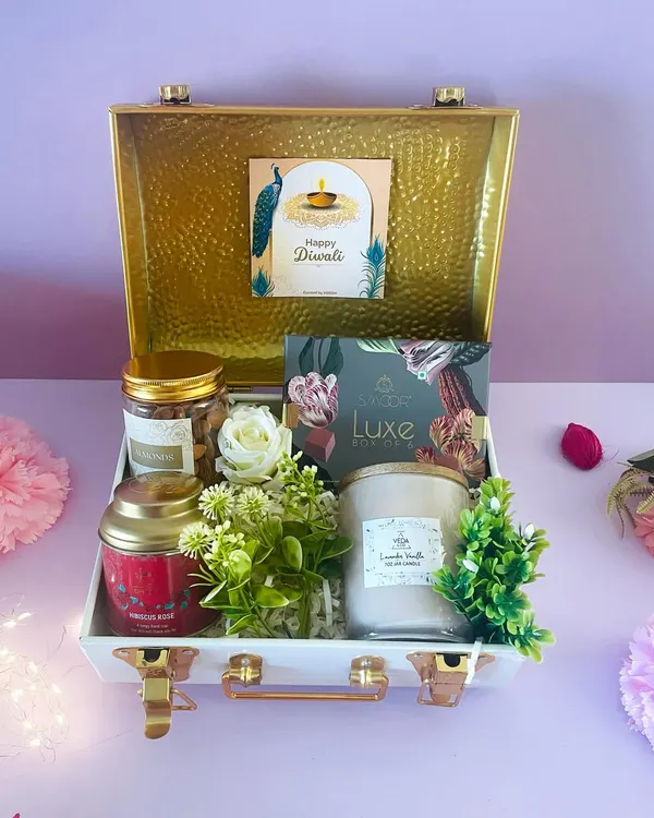 Experience true luxury with our stunning white and gold metal trunk. This hamper is curated with premium candles, chocolates, and nuts for an opulent Diwali gift.