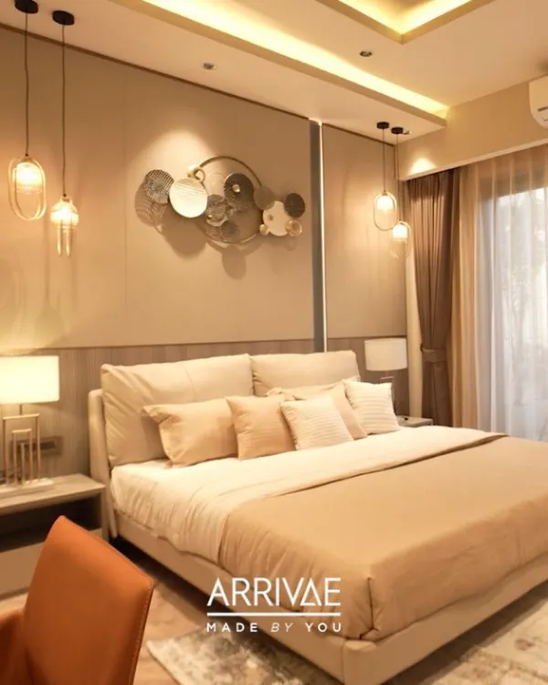 This master bedroom is the epitome of quiet luxury, with a plush, oversized headboard, soft ambient lighting from pendant lamps, and a soothing monochromatic beige color scheme.