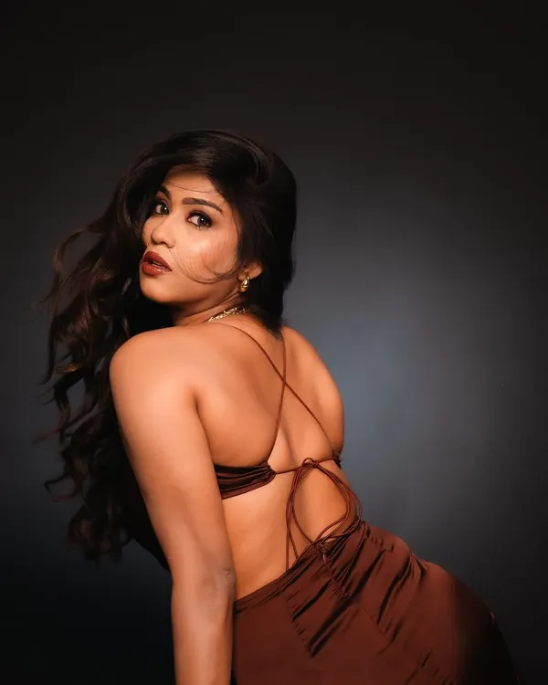 A powerful studio portrait using dramatic side lighting to highlight the model's features and the texture of her hair. The focus on the backless design of the dress adds a touch of allure and sophistication.