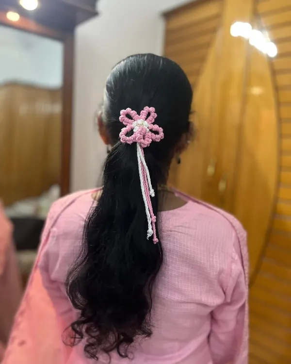A beautiful pink and white macrame flower hair tie, perfectly adorning a simple ponytail. It adds such a delicate and pretty touch.