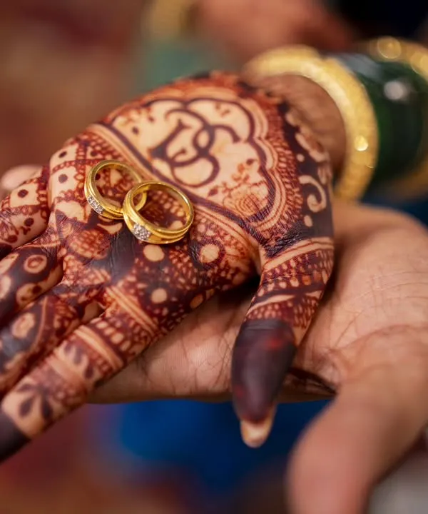 A promise held in hand. This close-up of the engagement rings on the bride's intricate mehendi is a story in itself.