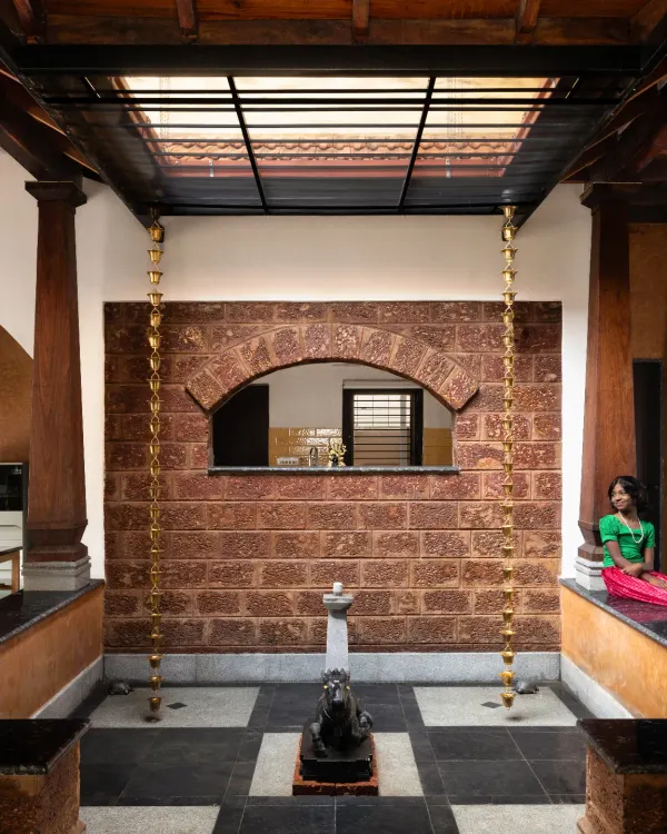 The central courtyard, or 'Thotti', of our Basavanagudi house is the breathing heart of the home. It connects the living spaces while inviting light, air, and even the rain inside, creating a constant dialogue with nature. This space features exposed laterite stone walls and traditional wooden pillars.
