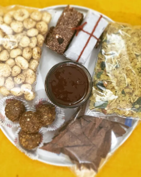 My travel-friendly snack platter, featuring spiced makhana, millet flakes mixture, gluten-free nachos, nutritional bars, and hazelnut nutella. Healthy eating, wherever you are.