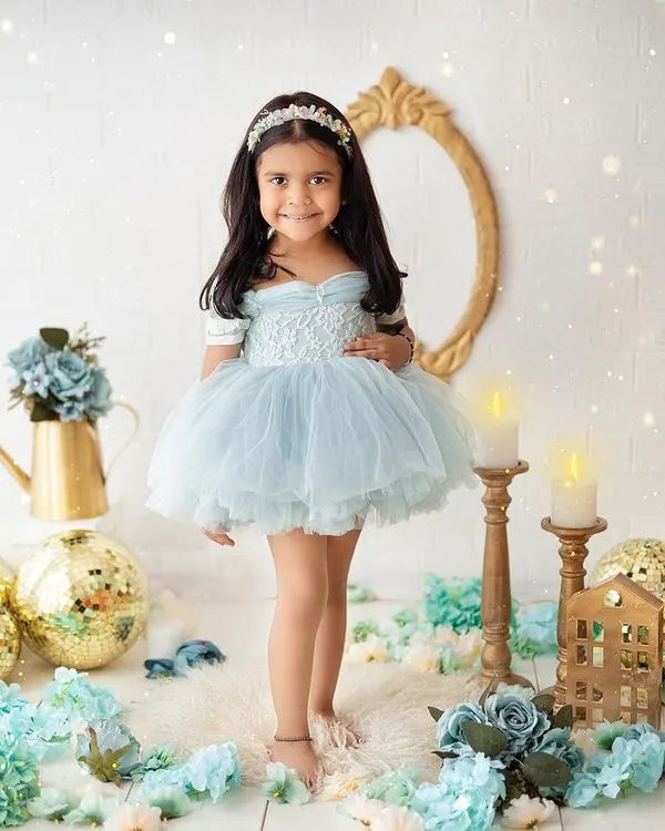 A beautiful princess in a world of blue and gold. This elegant studio portrait showcases a classic theme with a touch of sparkle and magic.