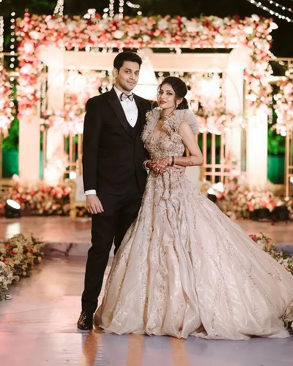 A picture perfect moment for the beautiful couple against the elegant reception stage we designed. The combination of soft florals, warm lighting, and intricate structures created a truly romantic backdrop.