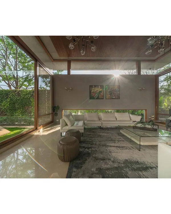 This living room in Bengaluru embodies our love for open, light-filled spaces. The floating roof and floor-to-ceiling glass walls dissolve the boundary between inside and out, making the garden an integral part of the home's interior design.