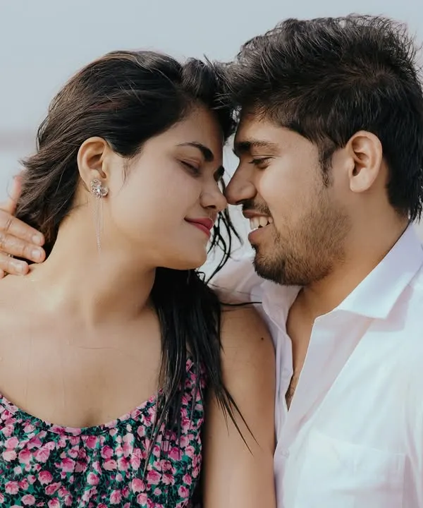 A beautiful close-up on the beach, capturing a moment of pure happiness and connection. The sea breeze and soft light make for a perfect romantic portrait.