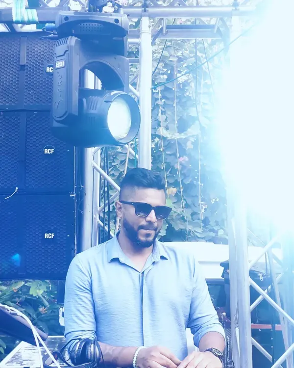 A cool, stylized shot of me at an outdoor event. The bright lighting and professional sound equipment in the background capture the scale of the events I play.