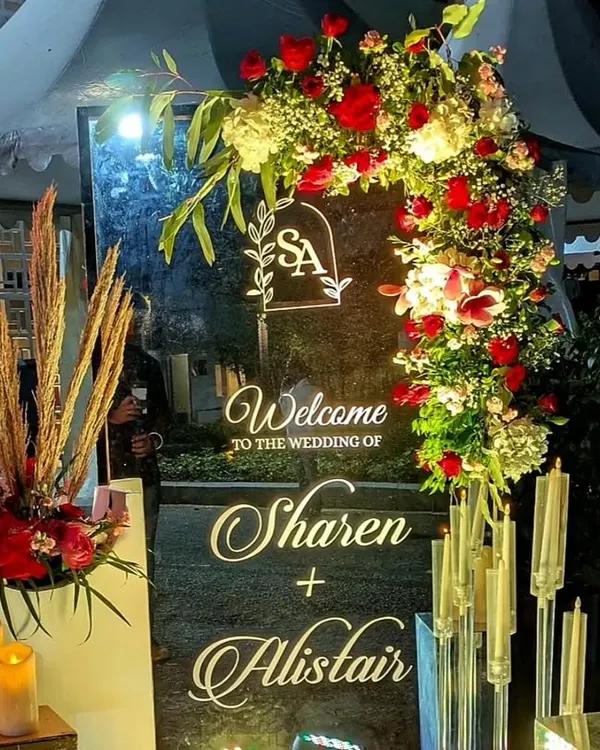 A personalized welcome sign is a beautiful way to greet your guests. For Sharen and Alistair, I designed this elegant mirrored sign with their monogram, framed by red roses and pampas grass.