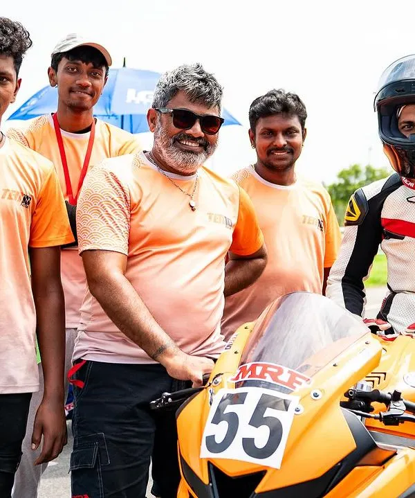 This is my team. I stand with my crew and a student racer after a successful session. I believe in a strong support system to help every rider grow, from the mechanics to the coaching staff.