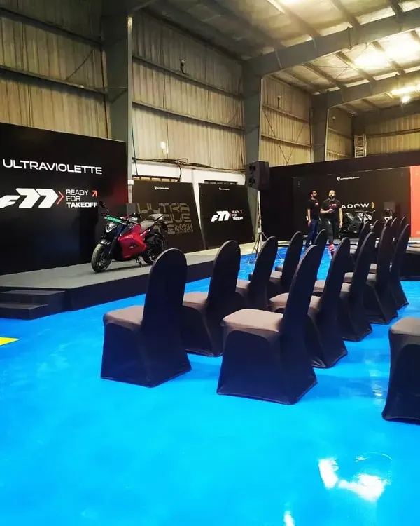 The stage and seating arrangement for the Ultraviolette automotive launch event. The industrial warehouse setting was transformed with strategic lighting and a custom stage to create a modern, edgy atmosphere for the brand reveal.