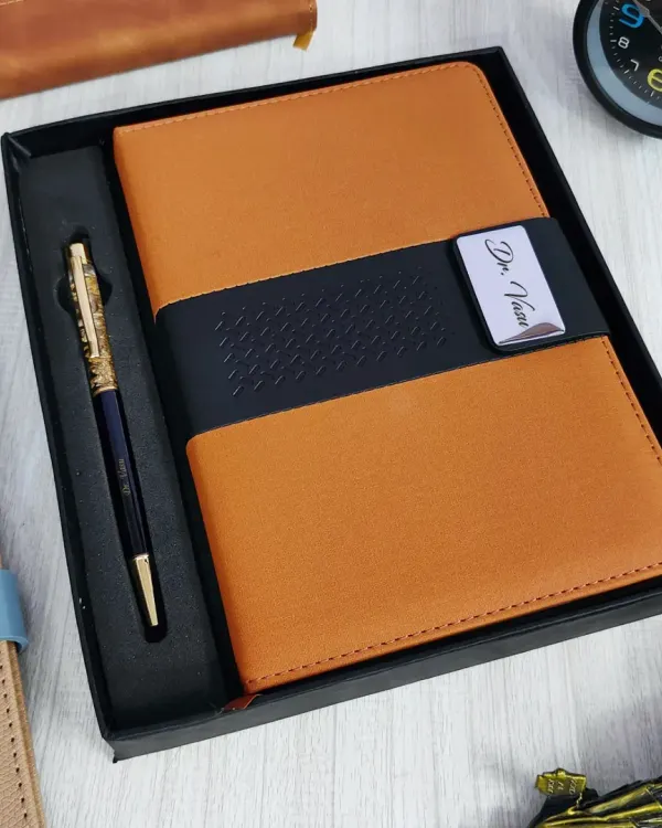A professional diary and pen set. The tan and black faux-leather diary has a metal plate engraved with "Dr. Vivan", and it comes with a matching premium pen in a gift box.