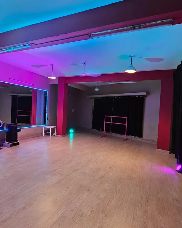 A glimpse of the studio's potential with dual-tone pink and blue lighting. This setup is perfect for creating dynamic, eye-catching content and highlights the ring light and ballet barre available for your use.