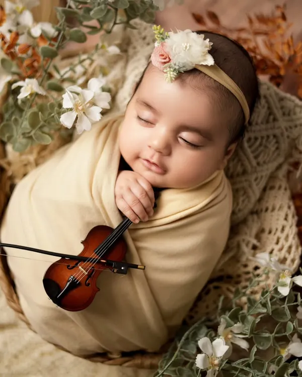 We believe every baby is a little masterpiece. For this newborn session, we created a peaceful, artistic setup with this tiny violin to capture a memory that feels like a sweet melody. It’s these quiet, beautiful moments we love to freeze in time.