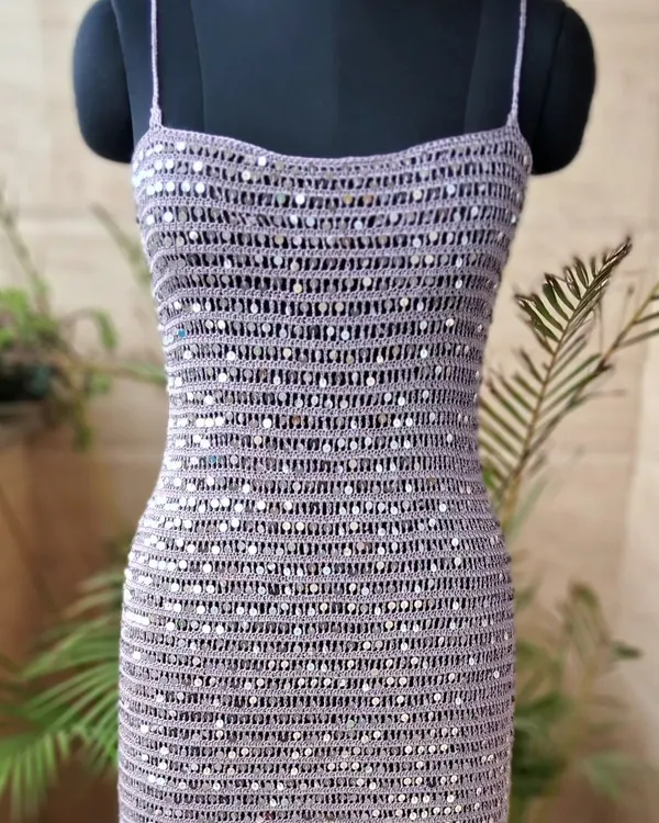 This handmade crochet cocktail dress, intricately woven with shimmering sequins, represents our vision of blending timeless craft with contemporary glamour. It's a statement piece designed to make you shine at any special occasion.