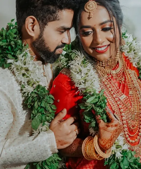 A close, intimate portrait of a South Indian couple, adorned with traditional garlands. I focus on capturing the loving glances and gentle smiles.