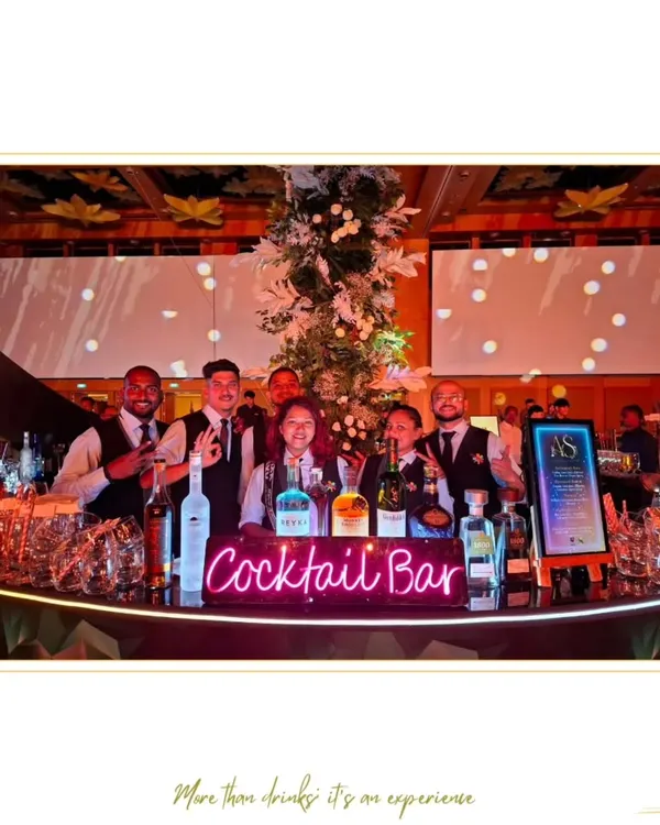 Our team behind a neon-lit "Cocktail Bar" at a grand wedding reception. We are equipped to handle large-scale celebrations with professionalism and style.