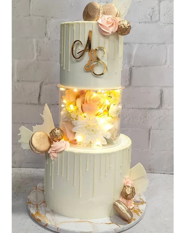 Welcome! I believe every celebration deserves a showstopper. This three-tiered cake, with its glowing LED lights and delicate white chocolate drip, is an example of how we can make your special day truly shine. I love taking a classic design and adding a modern, memorable twist.