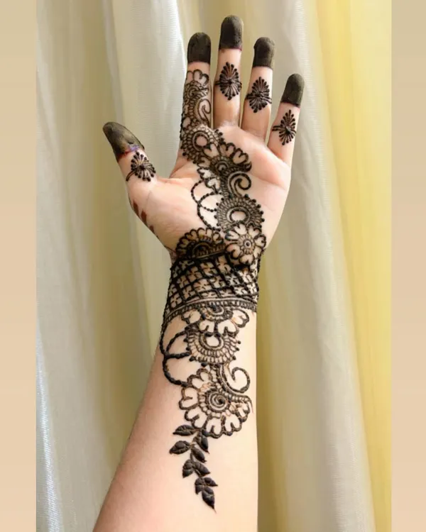 A classic Arabic bail design. The pattern starts from one finger and flows diagonally across the back of the hand, featuring flowers, leaves, and delicate swirls.