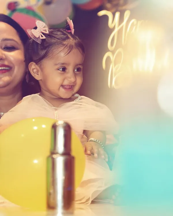A bright and happy portrait of the birthday girl. The soft lighting and her natural smile make this a perfect candid shot, capturing the pure joy of a child's celebration.