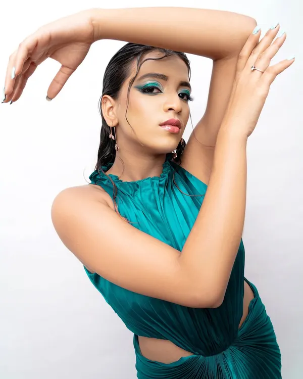 A modern fashion portrait with a wet hair look and bold teal eyeshadow. This style is perfect for a model's portfolio, showcasing a contemporary and edgy side.