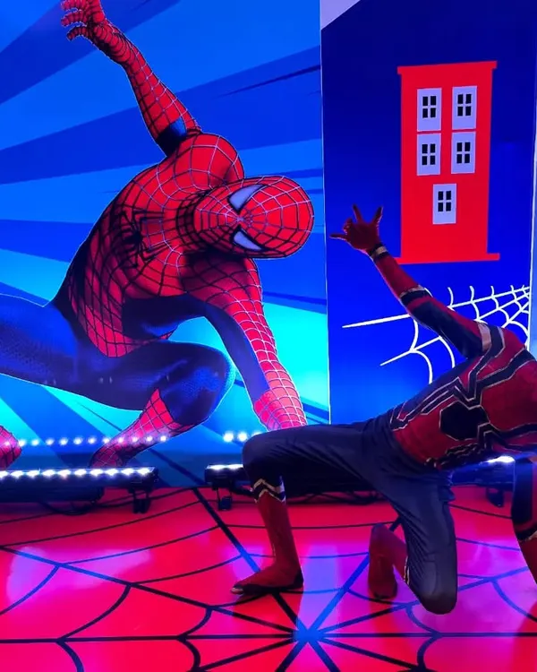 Double trouble! Our live Spiderman performer strikes a classic pose, perfectly mirroring the backdrop. This setup is amazing for photos at a superhero-themed birthday party.