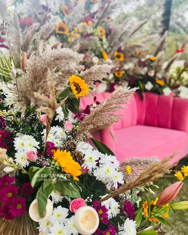 Detailing is everything in modern decor. This Mehendi setup combines a bold pink sofa with pampas grass, sunflowers, and other wildflowers to create a vibrant, bohemian look.