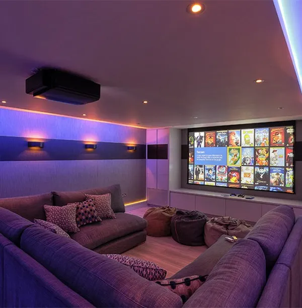 We create fully immersive home theatres tailored to your space. This setup features a ceiling-mounted projector, a large-format screen, and integrated ambient lighting to set the perfect movie-watching mood. The comfortable sectional sofa ensures there is plenty of room for family and friends.