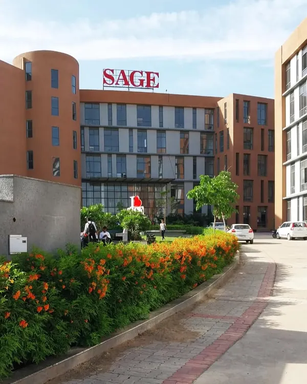 A view of the entrance and landscaped grounds of Sage University in Indore. The design uses local materials and climate-responsive features to create a sustainable and welcoming campus.