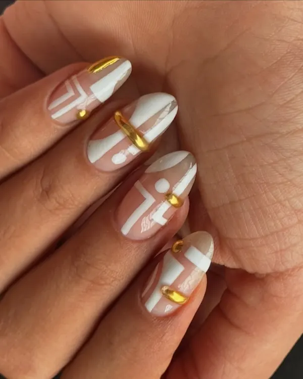 A modern and chic design featuring abstract white patterns on a nude base, accented with 3D gold rings and studs.