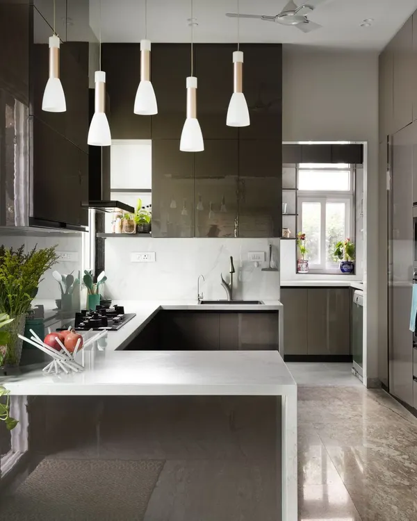 This kitchen from our Lakshya project is the heart of the home, filled with natural light. We designed it for a seamless flow, using sleek grey cabinetry that complements the floor's dramatic patterns and a white quartz countertop for a clean, modern finish. It’s a perfect example of how I create spaces that are both highly functional for daily life and beautifully uncluttered.