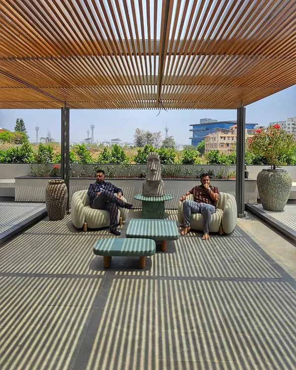 On this rooftop terrace, a wooden pergola creates a beautiful play of linear shadows, transforming the space into a dynamic canvas of light.