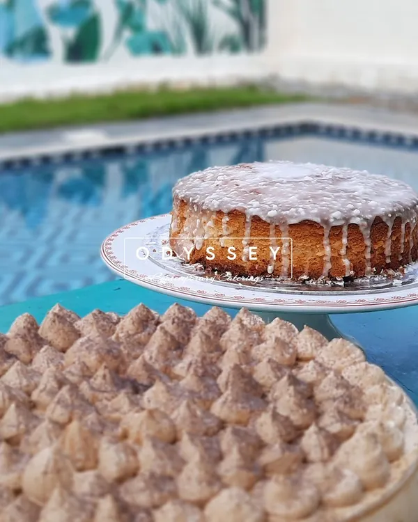A beautiful display of our cakes by the poolside. This image features a classic glazed cake and a rich tiramisu, showcasing our ability to create delicious desserts that are perfect for any celebration.