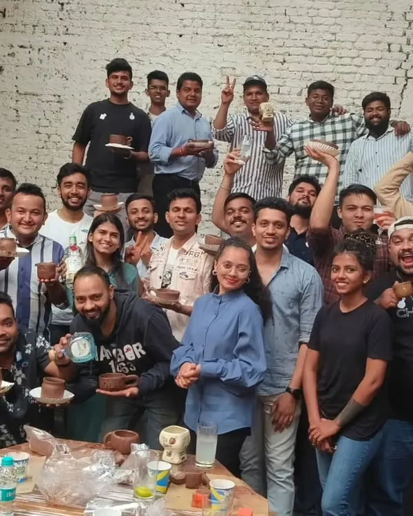 The entire team from a corporate workshop proudly holds up their creations. Our events are a fantastic team-building activity, fostering collaboration and creativity outside the office.