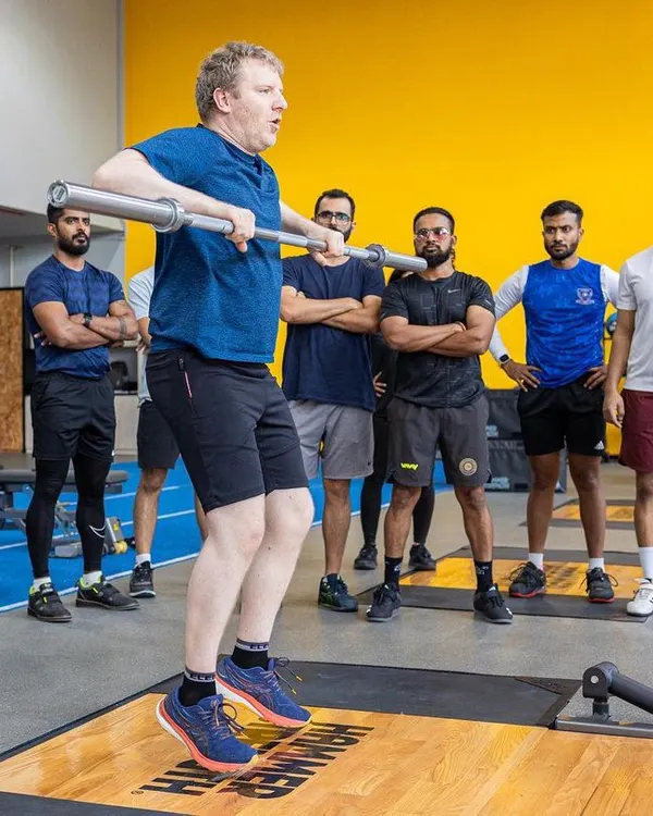An instructor demonstrates a weightlifting movement during a UKSCA course. Our workshops provide hands-on learning with expert trainers.