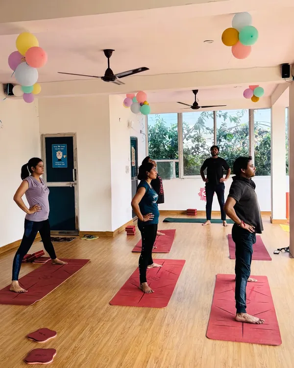 Students holding a standing pose during a class at our bright and airy Vikaspuri shala. The focus is on alignment and steady breathing.
