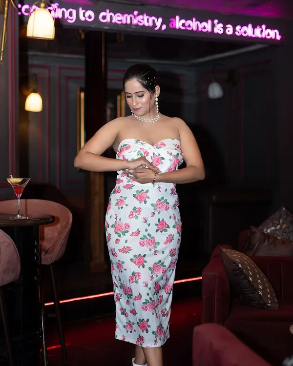 A lifestyle fashion shoot in a stylish cafe. The ambient lighting and location add a layer of sophistication to this shot of a model in a floral dress.