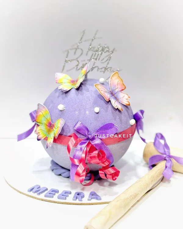This beautiful butterfly-themed piñata cake has a surprise mixed fruit cake hidden inside its chocolate shell. It comes with a decorated wooden hammer for the big reveal.