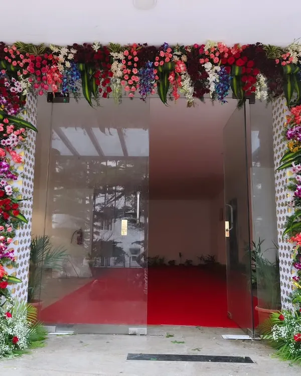 I create a grand and welcoming entrance for corporate office openings, like this full floral arch and red carpet setup for Trans cosmos. This design ensures your guests feel valued from the moment they arrive.