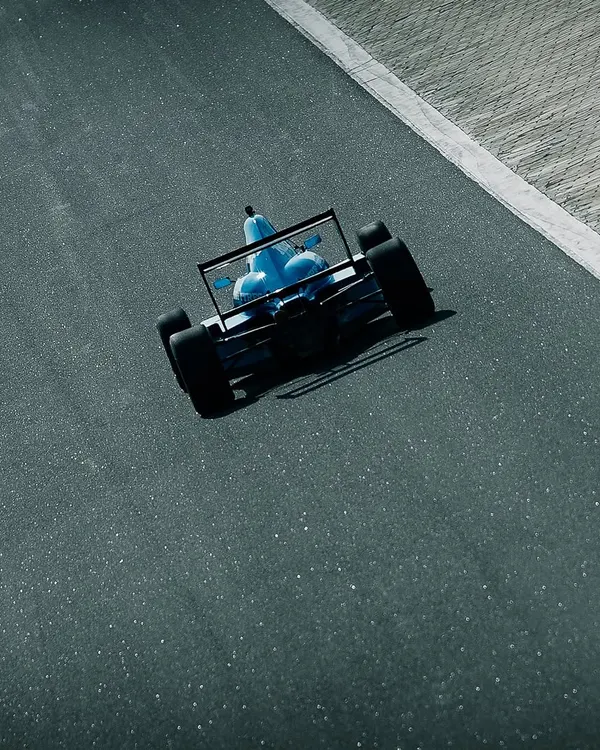 An aerial shot of our driver in a bright blue F1600 car, navigating the track at Kari Motor Speedway.