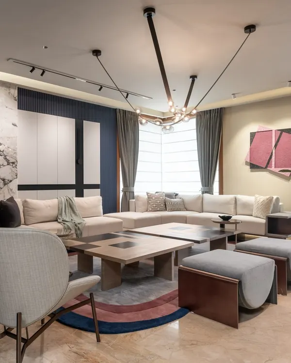 In this modern loft living area, we mixed a variety of materials to create a sophisticated feel. The space features a split central table, a colorful rug, and a striking marble wall panel, all working together to create a modern, luxurious ambiance.