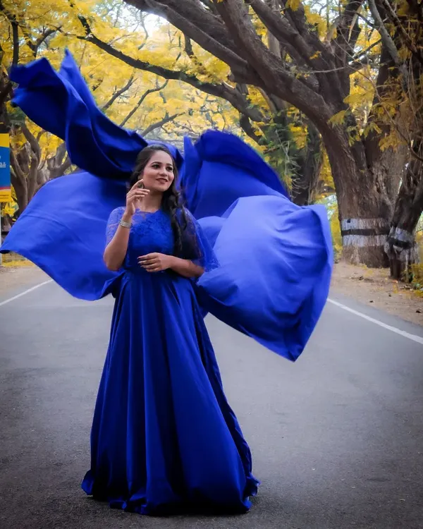 This royal blue gown with its large, detachable wings creates a powerful and elegant statement, perfect for an outdoor maternity photoshoot.