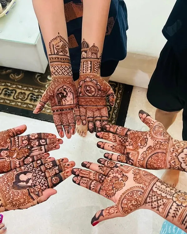 A lovely group shot of mehendi for the whole family. Each person has a unique design, from portraits to traditional patterns, reflecting their personal style.