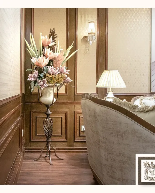 This elegant floral display, set in a classic urn on a sleek metal pedestal, is designed to be a standout piece in a corner or entryway. The arrangement adds height, color, and sophistication to the room.