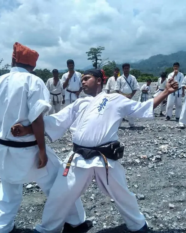 I lead by example. Here, at an outdoor training camp, I demonstrate a technique. We train in nature to build real strength, with mountains and sky as our dojo. This is the spirit of Kyokushin.