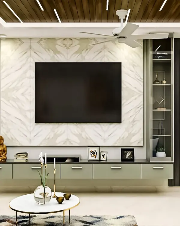 This modern living room features a full-wall TV unit we designed with a mix of materials. It includes a floating console with drawers, a glass display cabinet, and a stunning marble-finish backdrop, all framed by dark fluted panels and integrated ceiling lights.