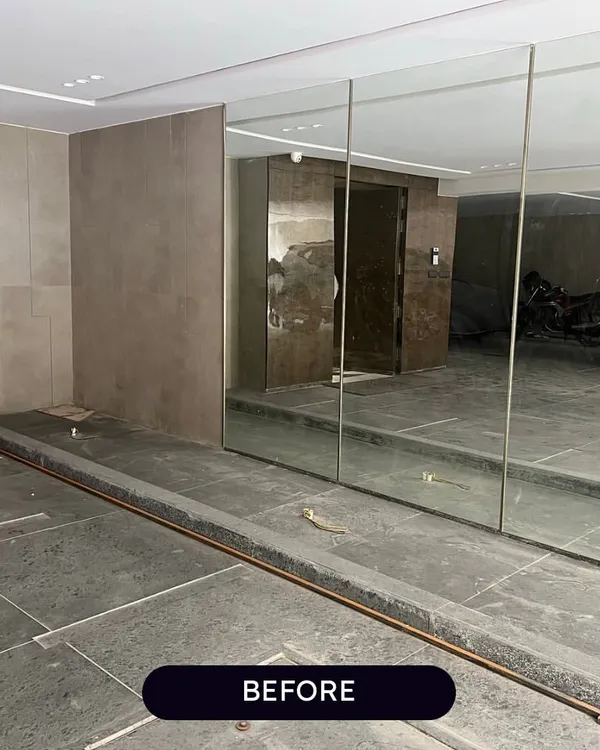 The "Before" shot of a parking-level entryway in Punjabi Bagh. This plain, empty planter box is the blank canvas for our transformation.