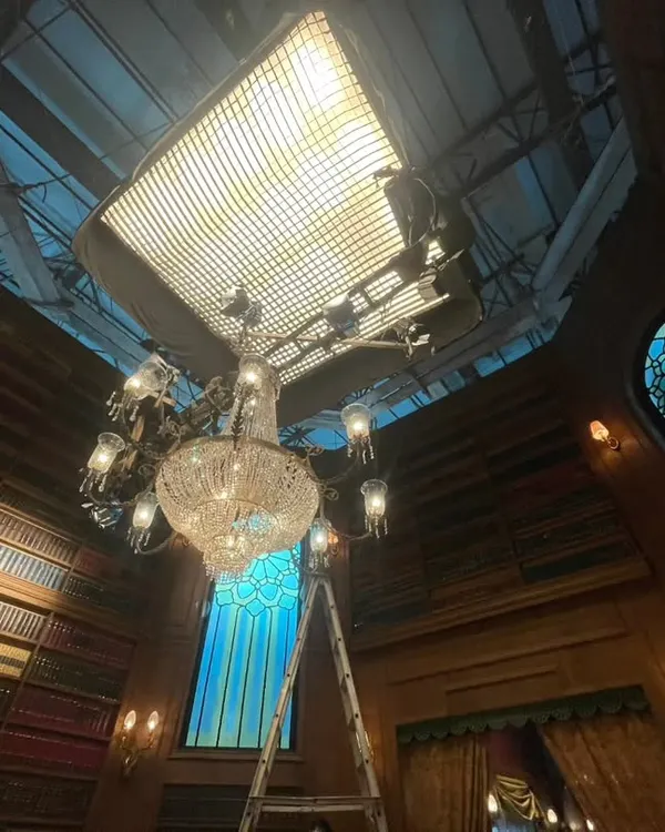 A massive Litegear Auroris soft light suspended with motorized hoists, creating a beautiful ambient glow over an intricate library set for a TV commercial. This setup demonstrates how we can achieve large, controllable soft sources even in complex environments.
